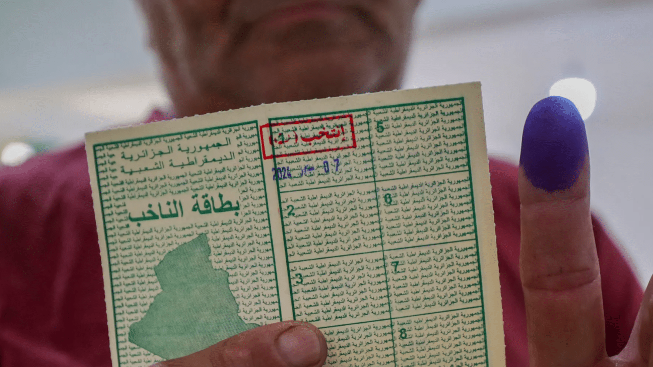 مواطن يحمل بطاقة الناخب بعد أن أنهى عملية الاقتراع